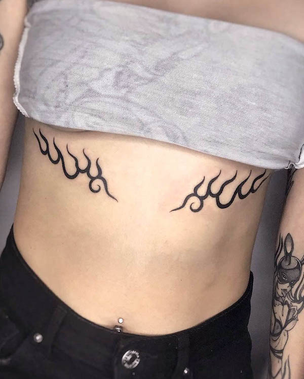 Tatuaggio tribale con fuoco sotto il seno by @sumiko.tattoo