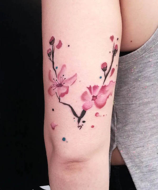 Tatuaggio femminile di fiori di ciliegio acquerellati di @freddy_tattoo_studio