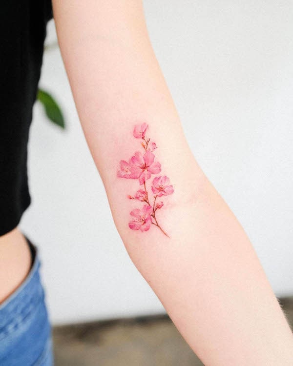 Piccolo tatuaggio di fiori di ciliegio sul braccio di @guseul_tattoo