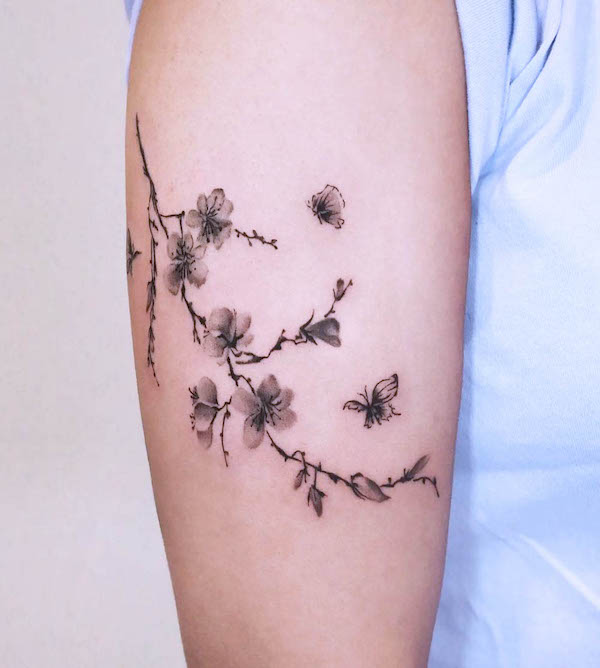 Tatuaggio con fiori di ciliegio neri e grigi di @yina_tattoo