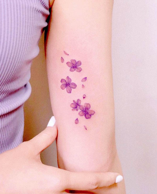 Tatuaggio unico con fiori di ciliegio viola di @peria_tattoo