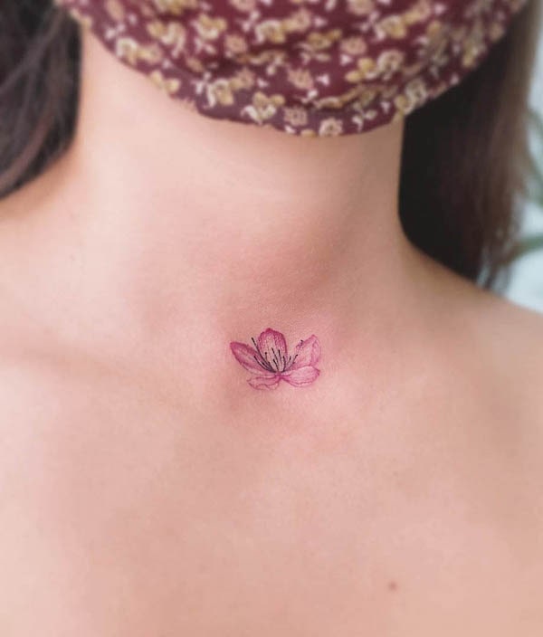 Piccolo tatuaggio sul collo con fiori di ciliegio di @eva_tattooist