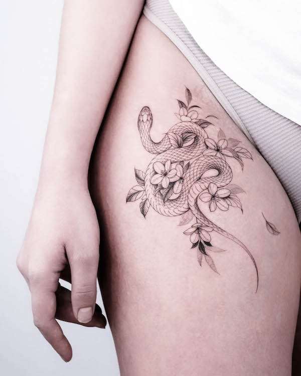 Tatuaggio di serpente e fiori di ciliegio sulla coscia di @la_source_tattoo