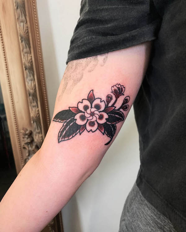 Tatuaggio tradizionale con fiori di ciliegio di @shanjitattoo