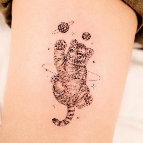 Tatuaggio di @dan_tattooer con bambino tigrato e pianeti