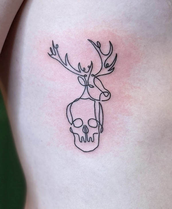 Tatuaggio con una linea di corna e teschio di @jennaloredo_tattoo