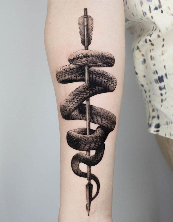 Tatuaggio realistico con serpente e freccia di @ogitattooer