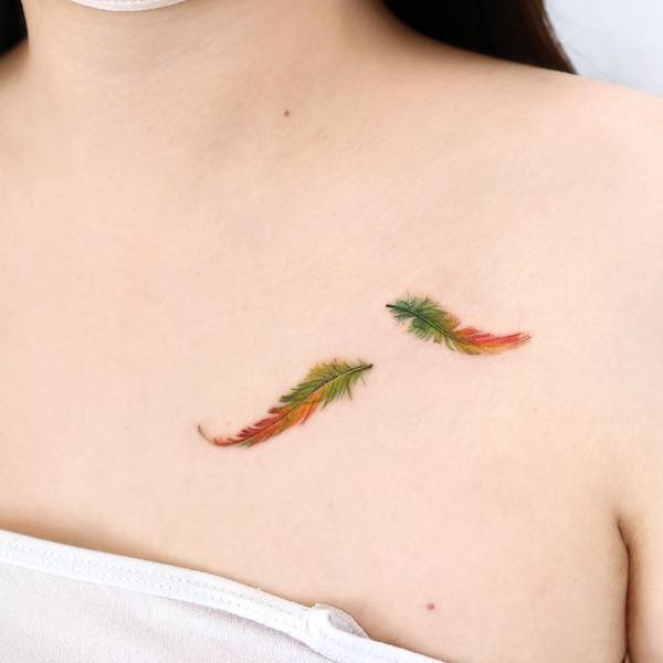 Tatuaggio con piccola piuma verde e arancione di @palette.tt