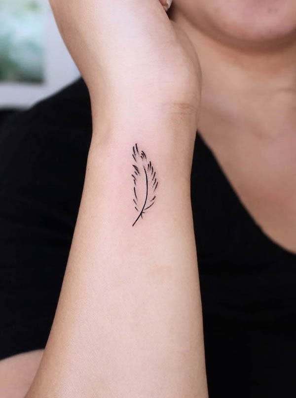 Tatuaggio minimalista del polso con piume di @uhhhhtaco