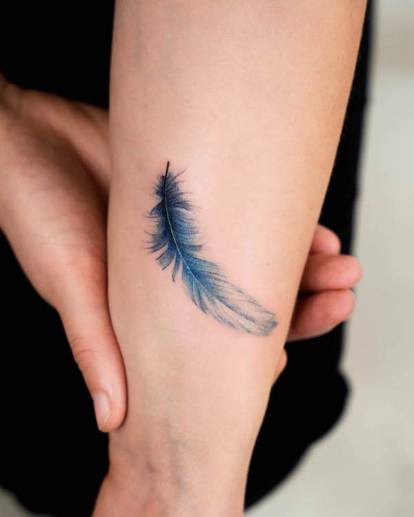 Piccolo tatuaggio da polso con piume blu di @_rony_tattoo