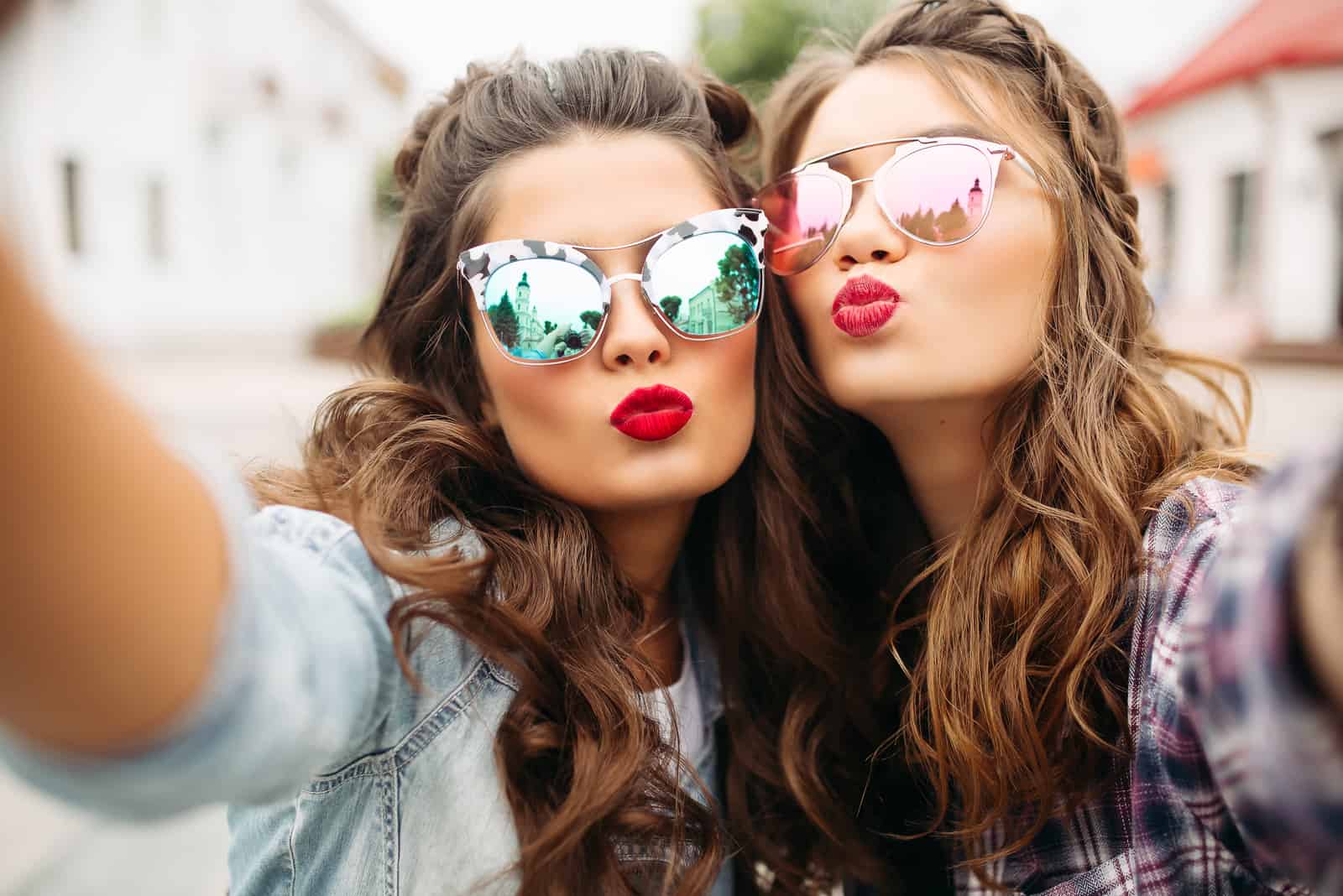 due donne con labbra rosse e capelli ondulati