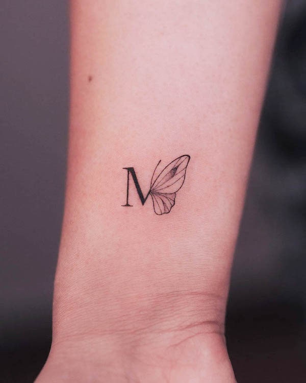 Tatuaggio con iniziale e farfalla a linea fine di @cha.tattoo