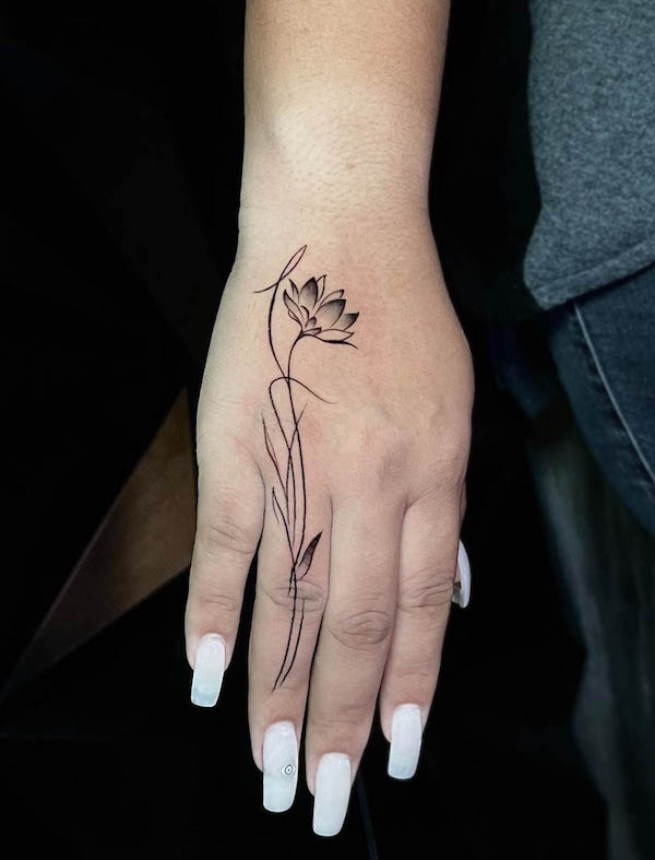 Tatuaggio unico della mano del loto da @poisontattoosupply