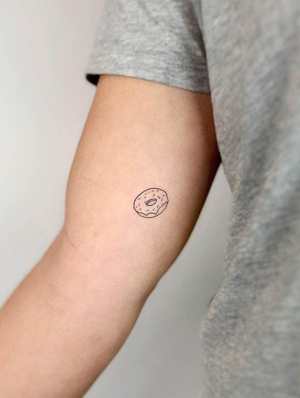 Piccolo e semplice tatuaggio a forma di ciambella a linea fine di @cha.tattoo
