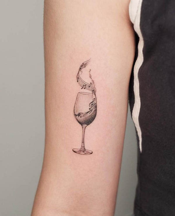 Tatuaggio a linea fine di musica e bicchiere di vino da @grayscale.tattoo