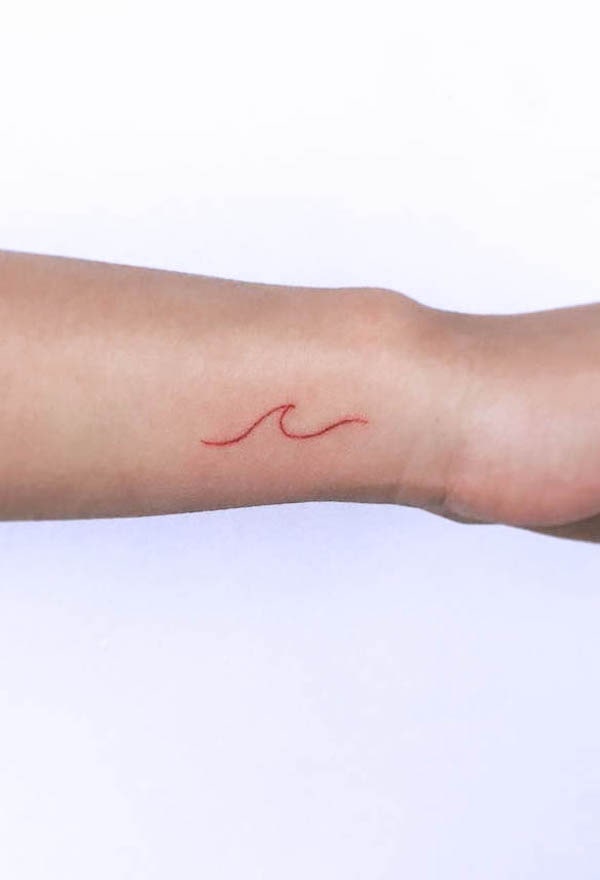 Tatuaggio del polso con onde rosse di @tattoobyok