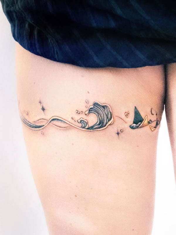 Tatuaggio a fascia sulla coscia con onde dorate di @tattooist_toma