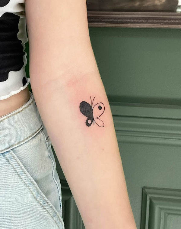Tatuaggio minimalista con farfalla yin yang di @mclametattoos