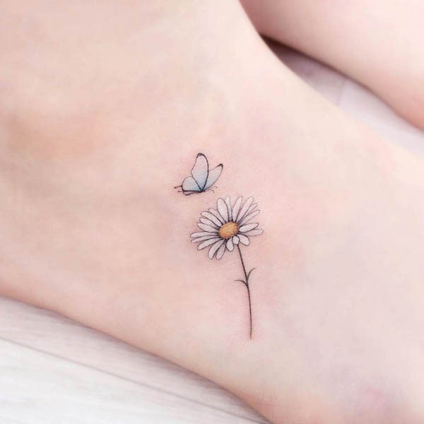 Tatuaggio del piede con farfalla e margherita di @tattooist_greem