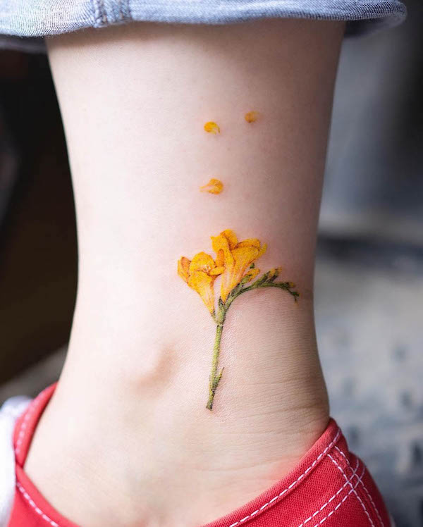 Tatuaggio del piede con fiore di fresia di @pokhy_tattoo