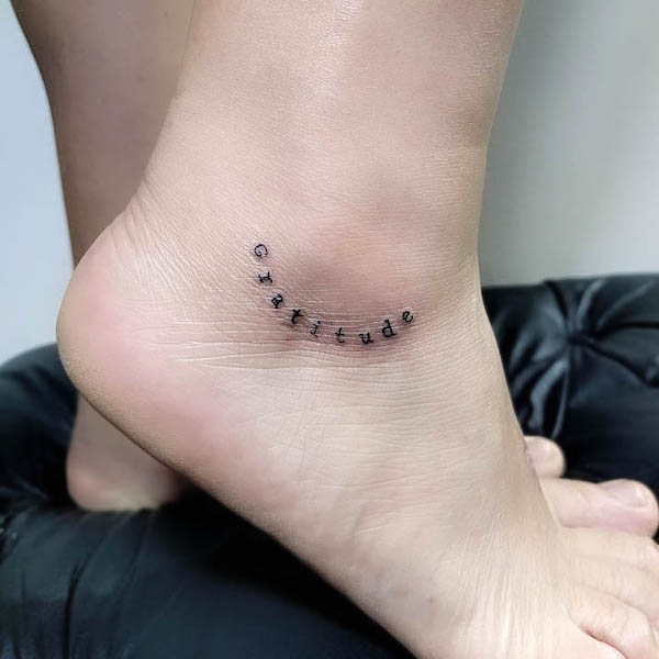 Tatuaggio alla caviglia con una parola di gratitudine di @barbaraguerrart