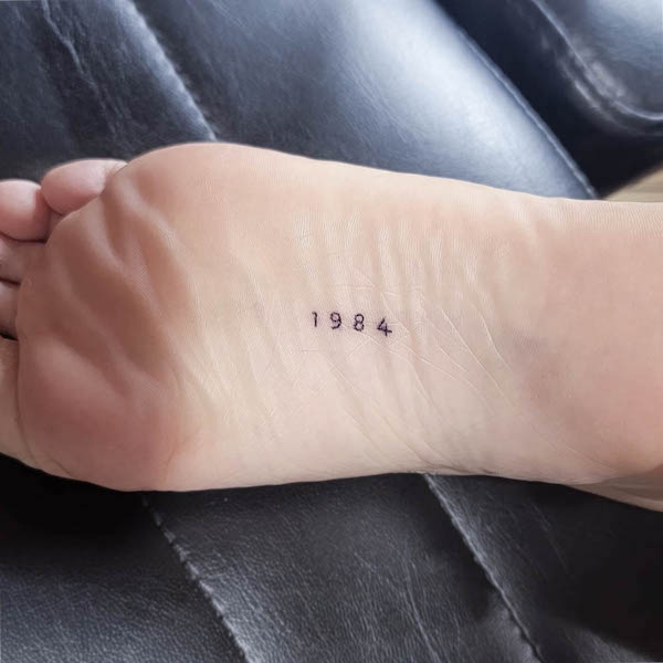 Tatuaggio del piede dell'anno di nascita di @crybabytattooer
