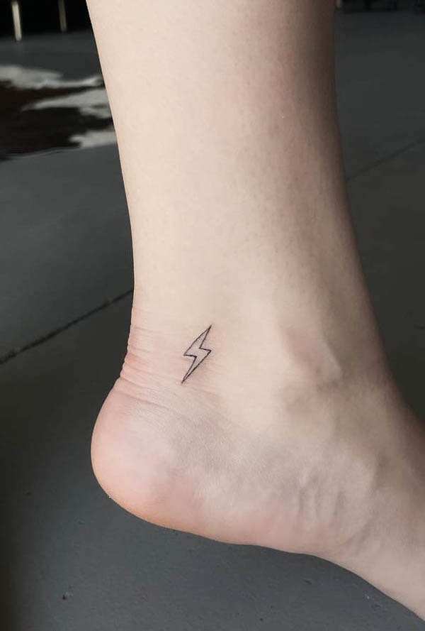Piccolo tatuaggio di un piede fulminato di @finelinesby.aj