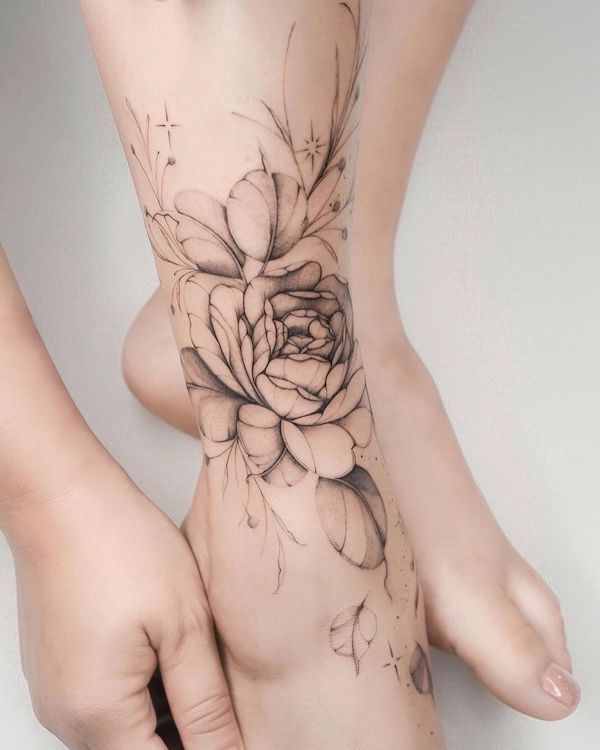 Tatuaggio del piede con fiore in scala di grigi di @lasstattoo