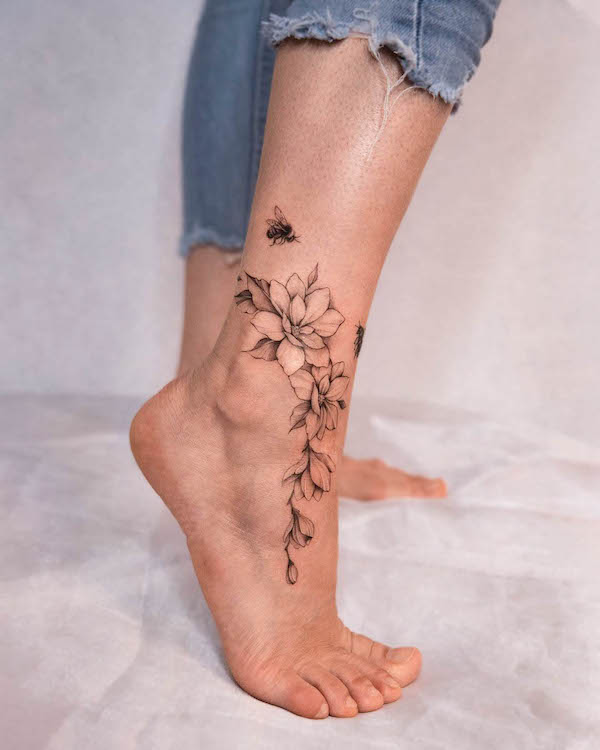 Tatuaggio del piede con ape e fiori di @polar.tattooing
