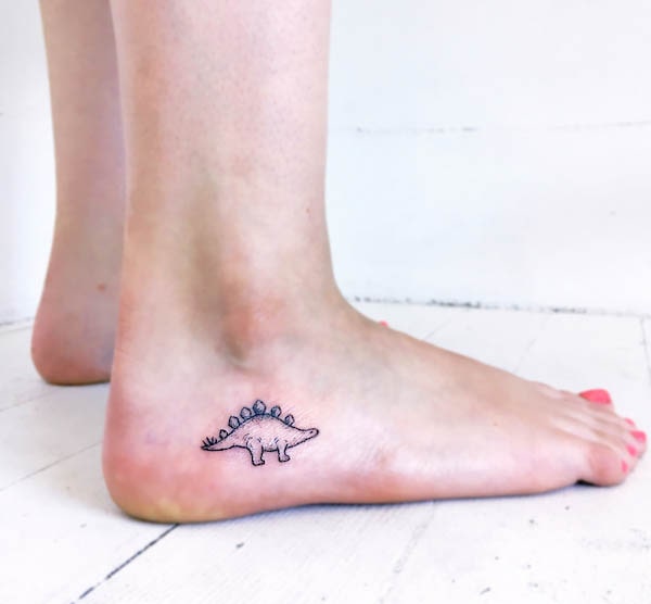 Piccolo tatuaggio di piede di stegosauro da @ink.dust_