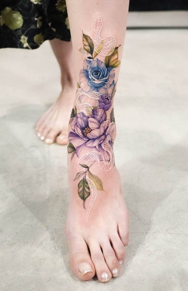 Serpente bianco e fiori tatuato sul piede da @tattooist_silo
