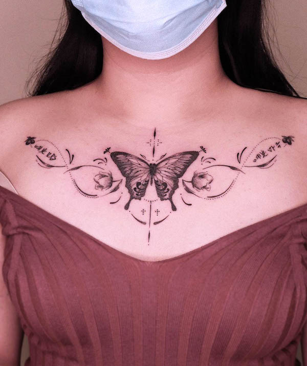 Tatuaggio sul petto con farfalla nera e grigia di @cocotattooer