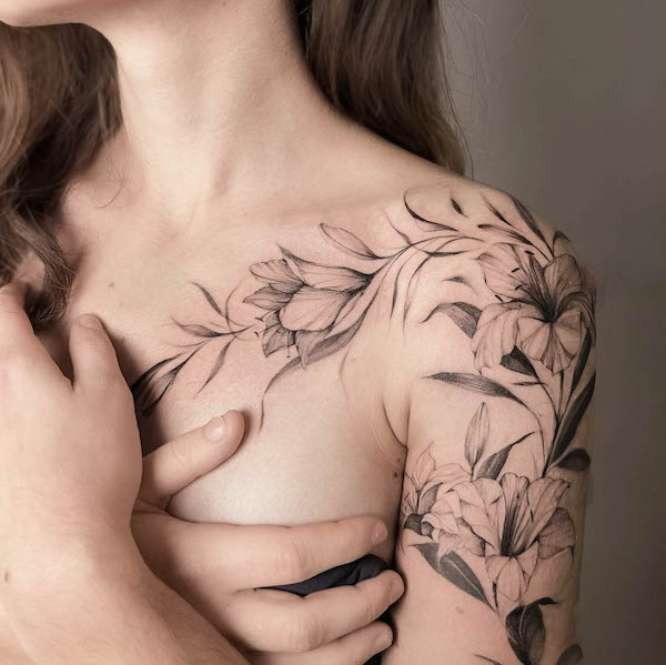 Tatuaggio floreale nero e grigio dal petto alla spalla di @ela_fine_tattoo