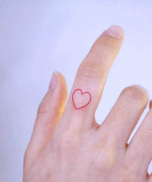 Tatuaggio con dito a forma di cuore rosso di @inkedout_tattoo