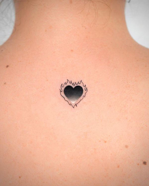 Tatuaggio cuore nero bruciante di @o.ri_tattoo