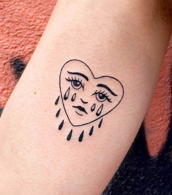 Tatuaggio bicipite con cuore piangente di @doostuff
