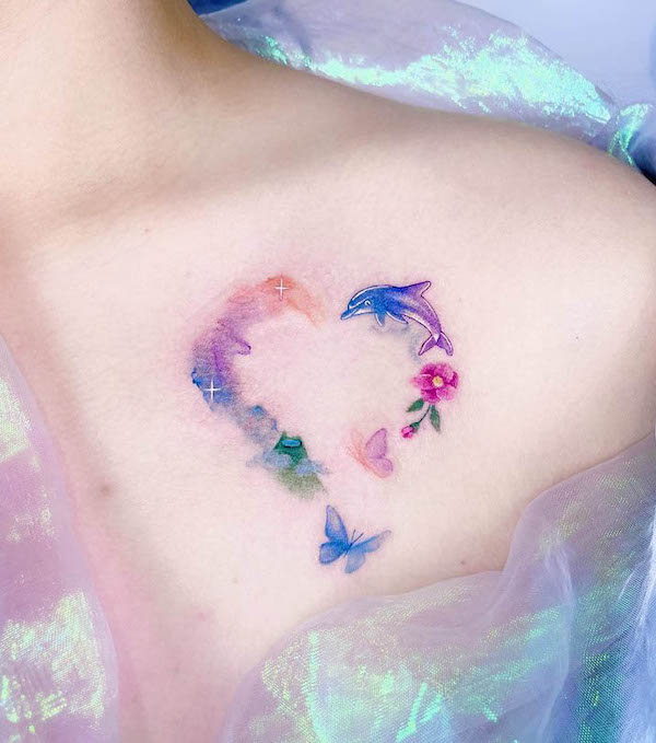 Tatuaggio a cuore acquerellato con farfalle e delfino da @plastic_tattoo