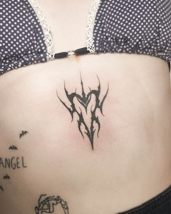 Tatuaggio tribale con cuore sullo sterno di @sixtyink