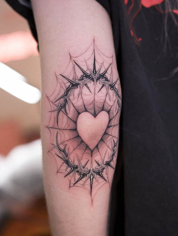 Tatuaggio con cuore sul gomito a forma di ragnatela di @__danykim