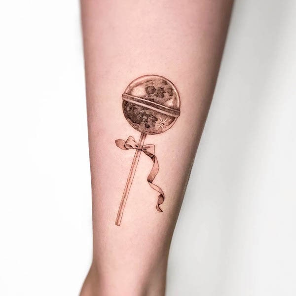 Tatuaggio carino con lecca-lecca nero e grigio di @mogiz.tattoo
