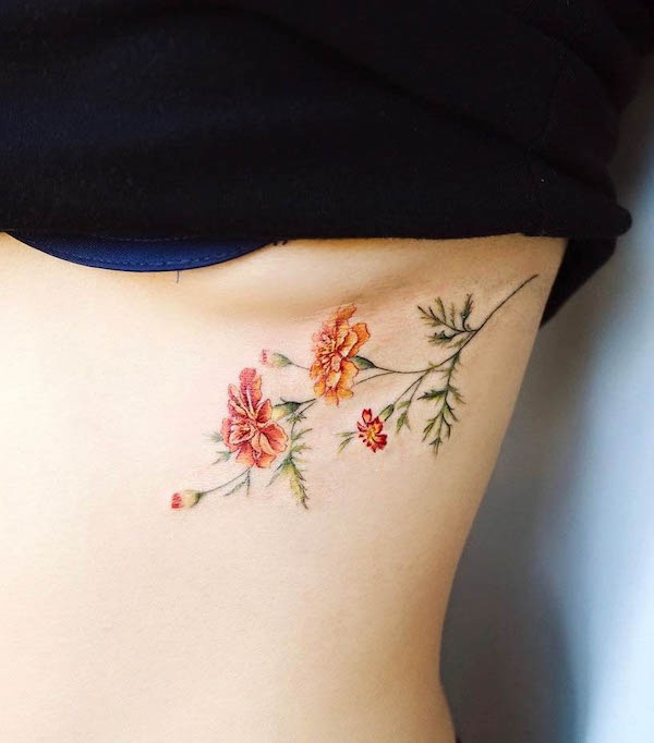 Simpatico tatuaggio a fiori colorati sotto il seno di @vane.tattoo