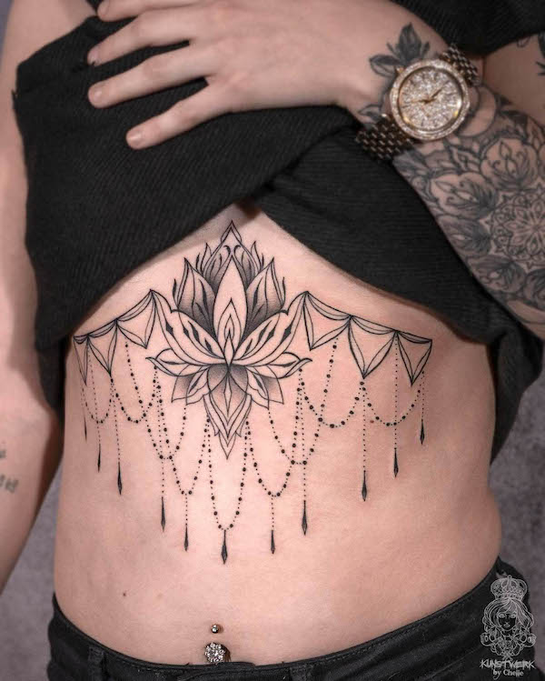 Tatuaggio sotto il seno con loto in grassetto di @kunstwerk.chelle