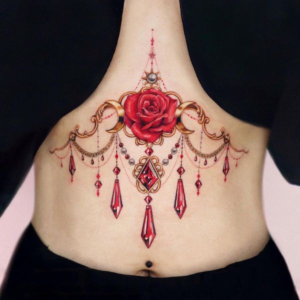 Rosa e gioielli sotto il seno tatuato da @yeriel_tattoo