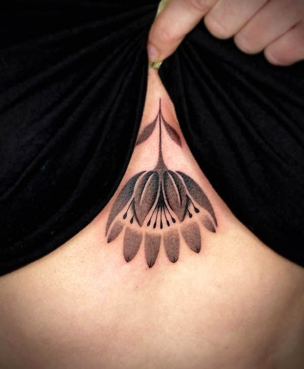 Tatuaggio con fiore invertito nero e grigio di @entala_tattoo
