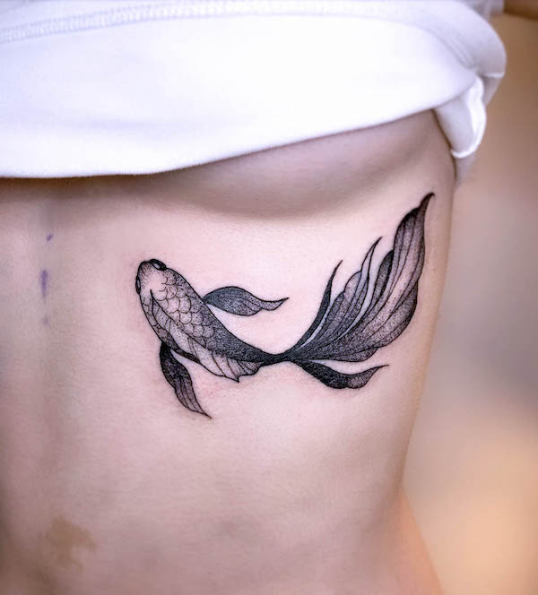 Tatuaggio di pesce Koi sotto il seno di @ariatattooing