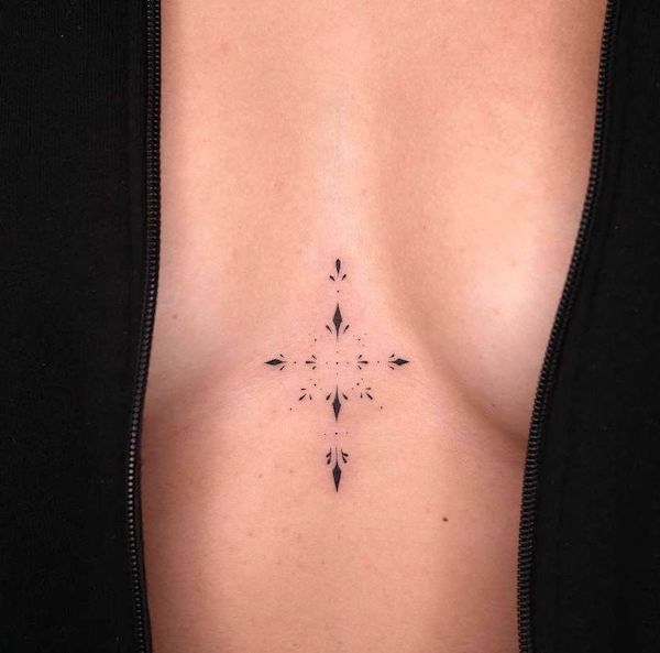 Tatuaggio ornamentale minimalista sotto il seno di @zahaitattoo