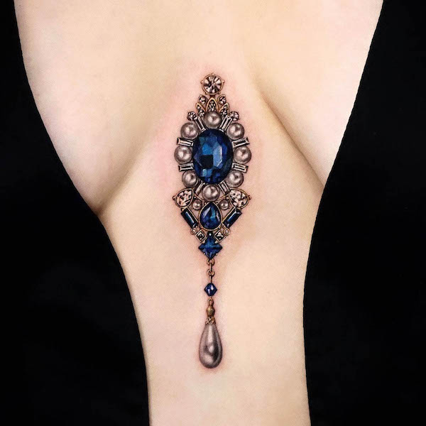 Ciondolo di pietra preziosa tra le tette di @yeriel_tattoo