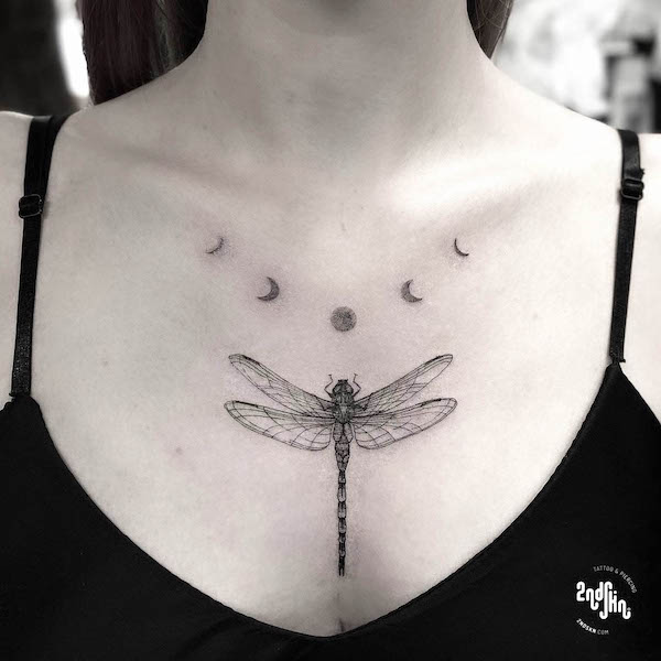 Libellula e fasi lunari tatuate sul petto da @2ndskintattoo