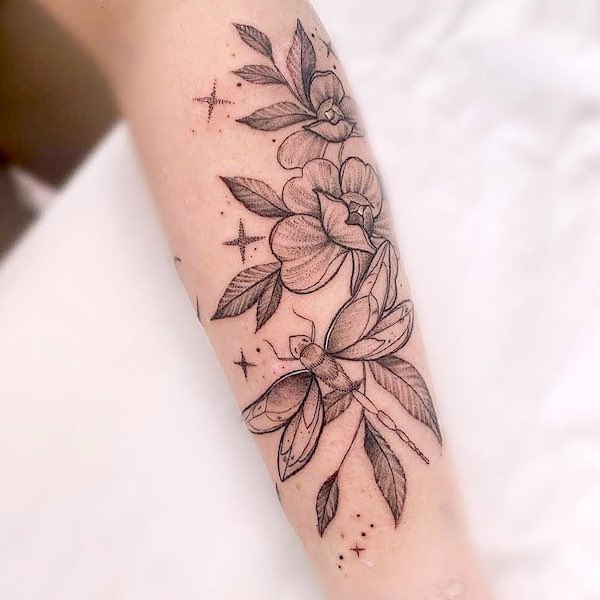 Tatuaggio floreale con libellula sull'avambraccio di @abievetattoo