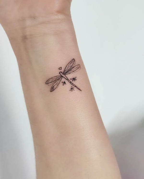 Tatuaggio da polso di @l.ink_tattoos con libellula piccola e carina